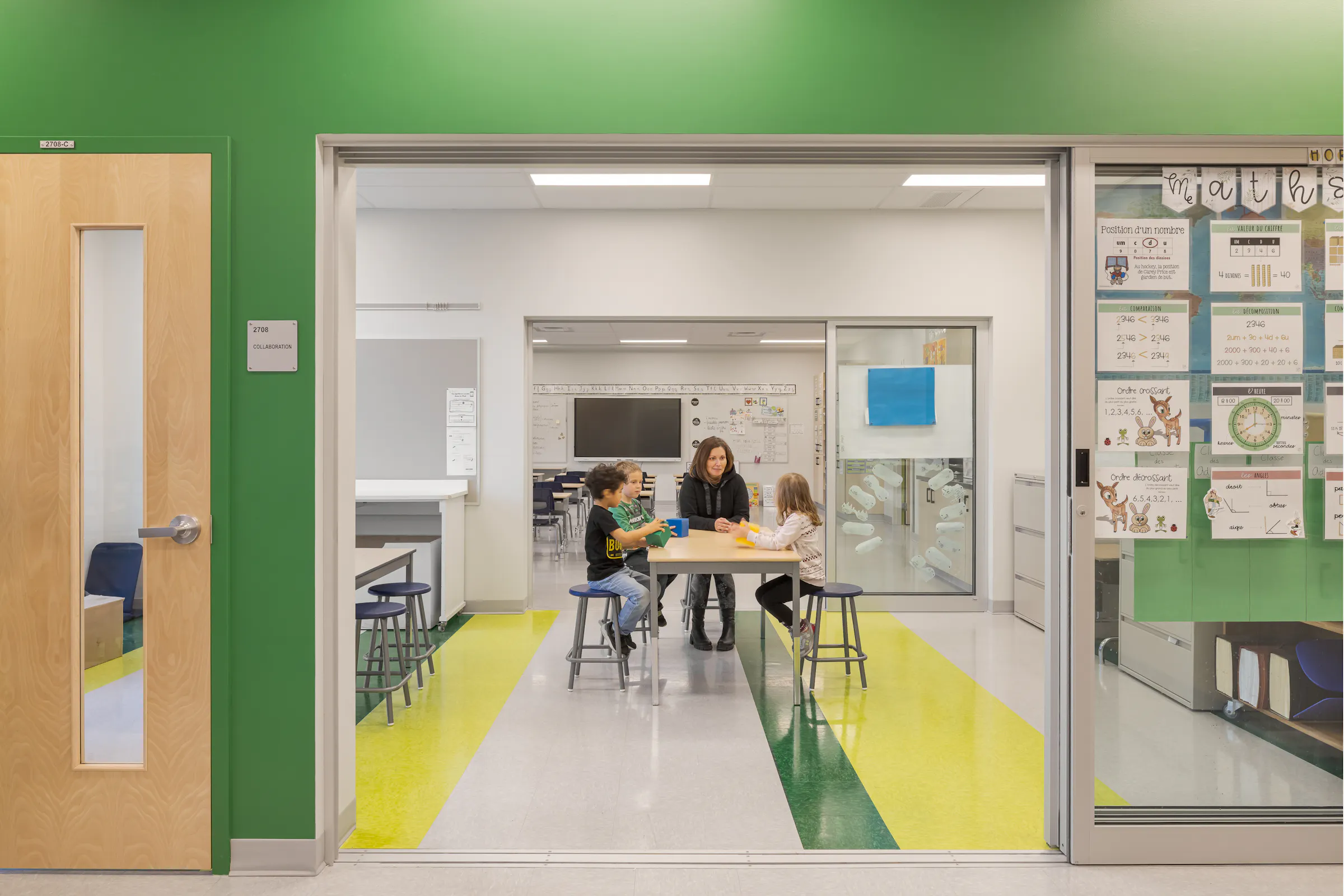 A glass-walled collaborative workspace adjacent to the classrooms, with students engaged in activities, modular furniture, and a whiteboard. Photo: TARMAC - Damien Ligiardi