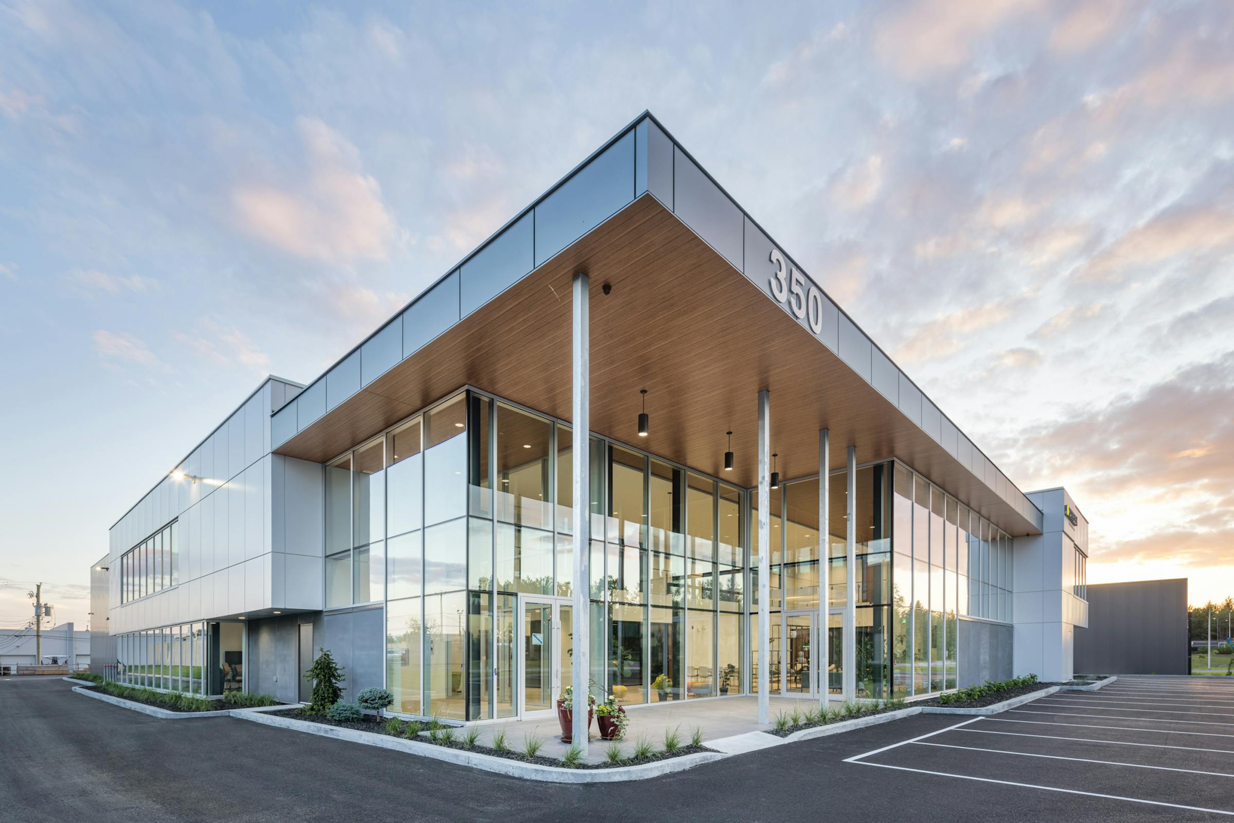 Architectural photography of a commercial building at sunset with colorful clouds. 3/4 view with dominant natural light.