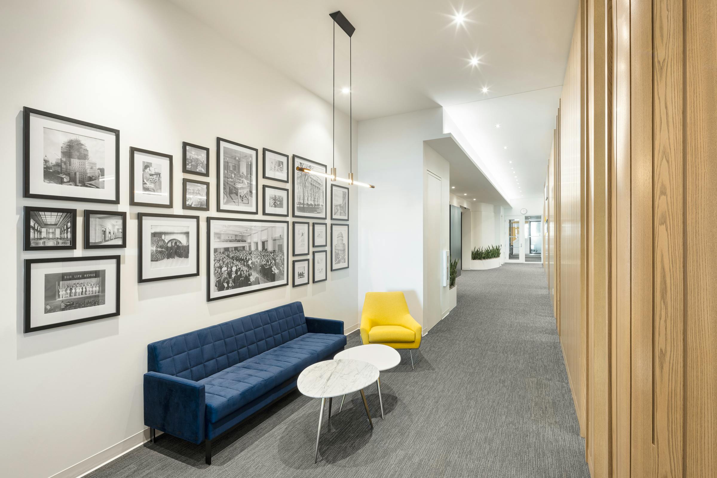 Interior design of corporate offices with modern and colorful furniture. A large wooden wall and vintage photographs on the walls.