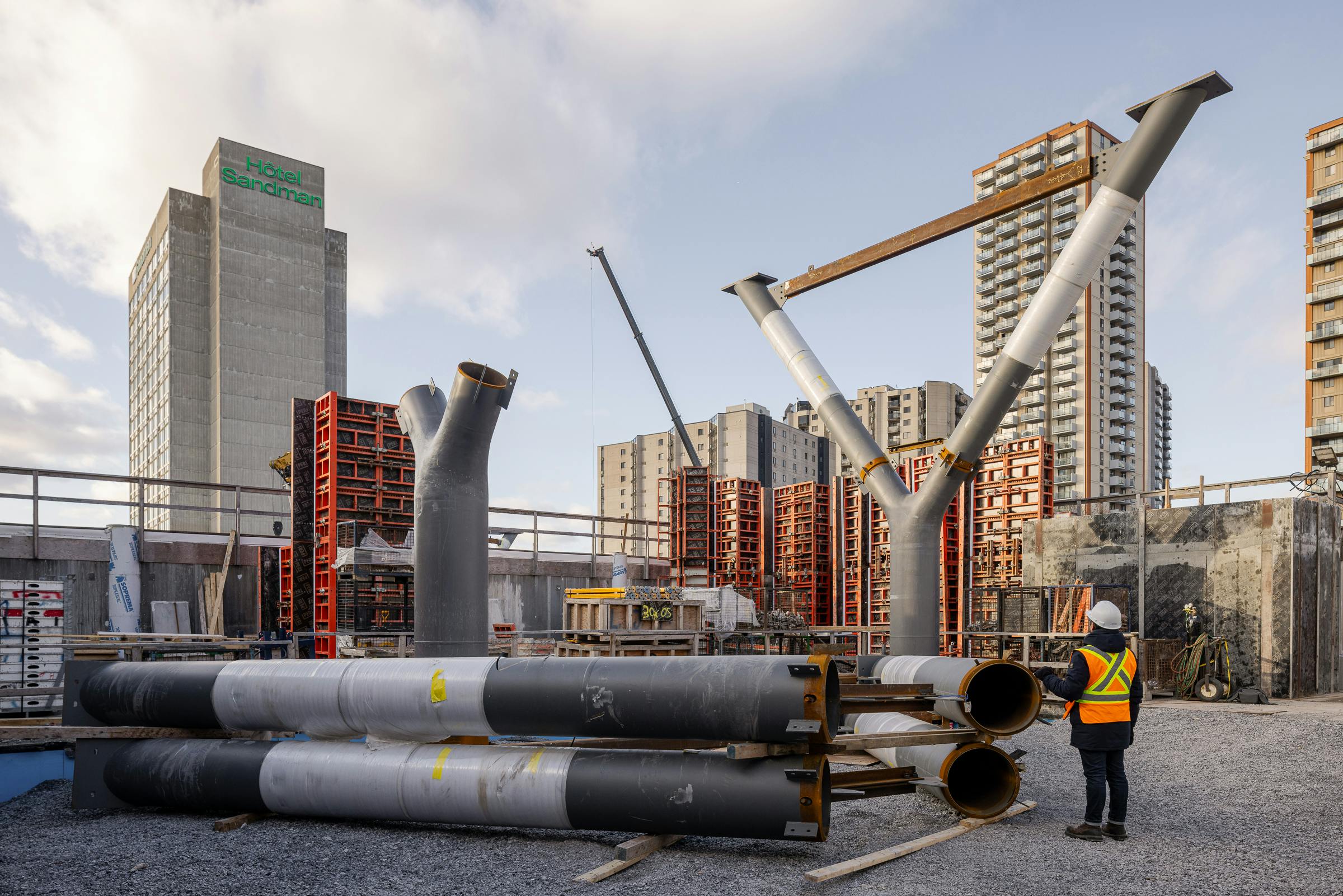 Mise en évidence de la taille des structures en forme d'arbres avec un ouvrier au premier plan.