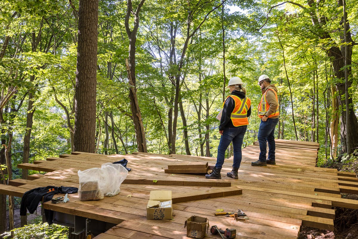 Workers planning the construction of a wooden platform in Quebec.