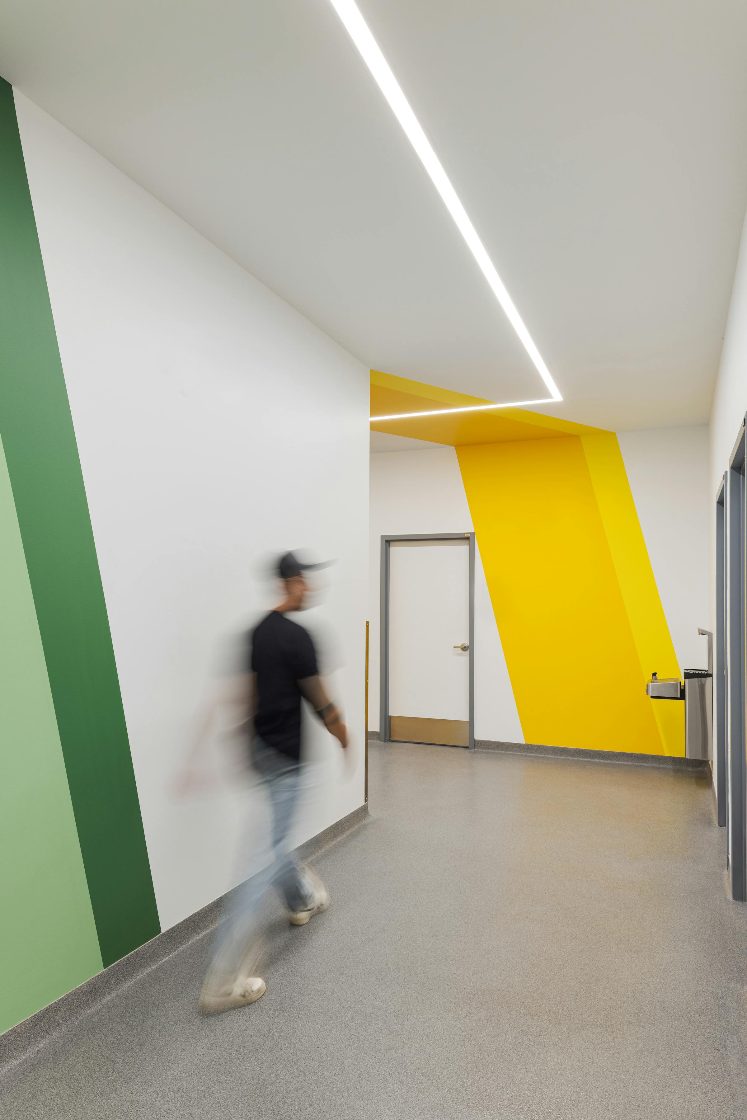 Corridor with a moving silhouette and colorful sections and architectural lighting.
