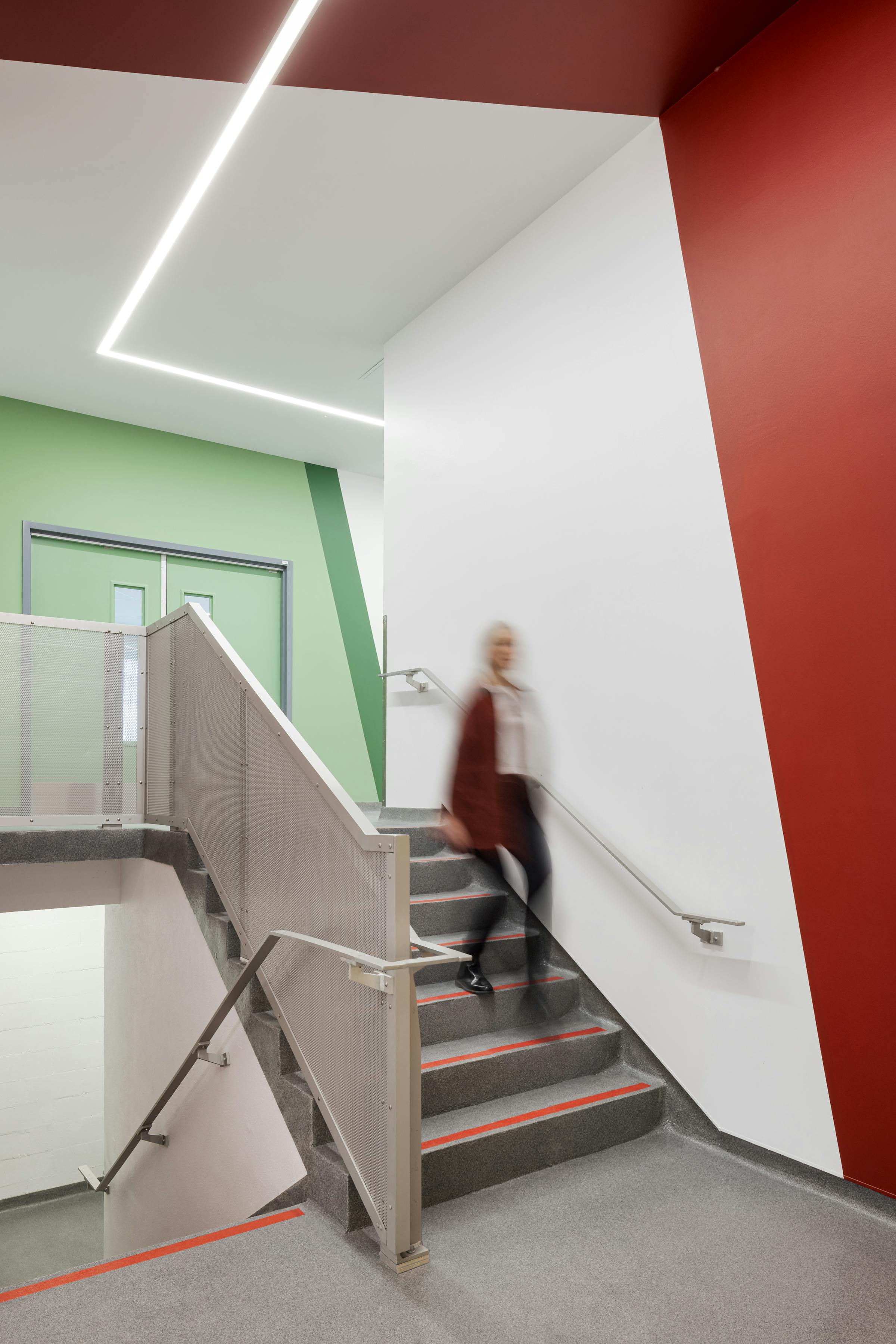Corridor and architectural staircase in a colorful building and with a moving silhouette.