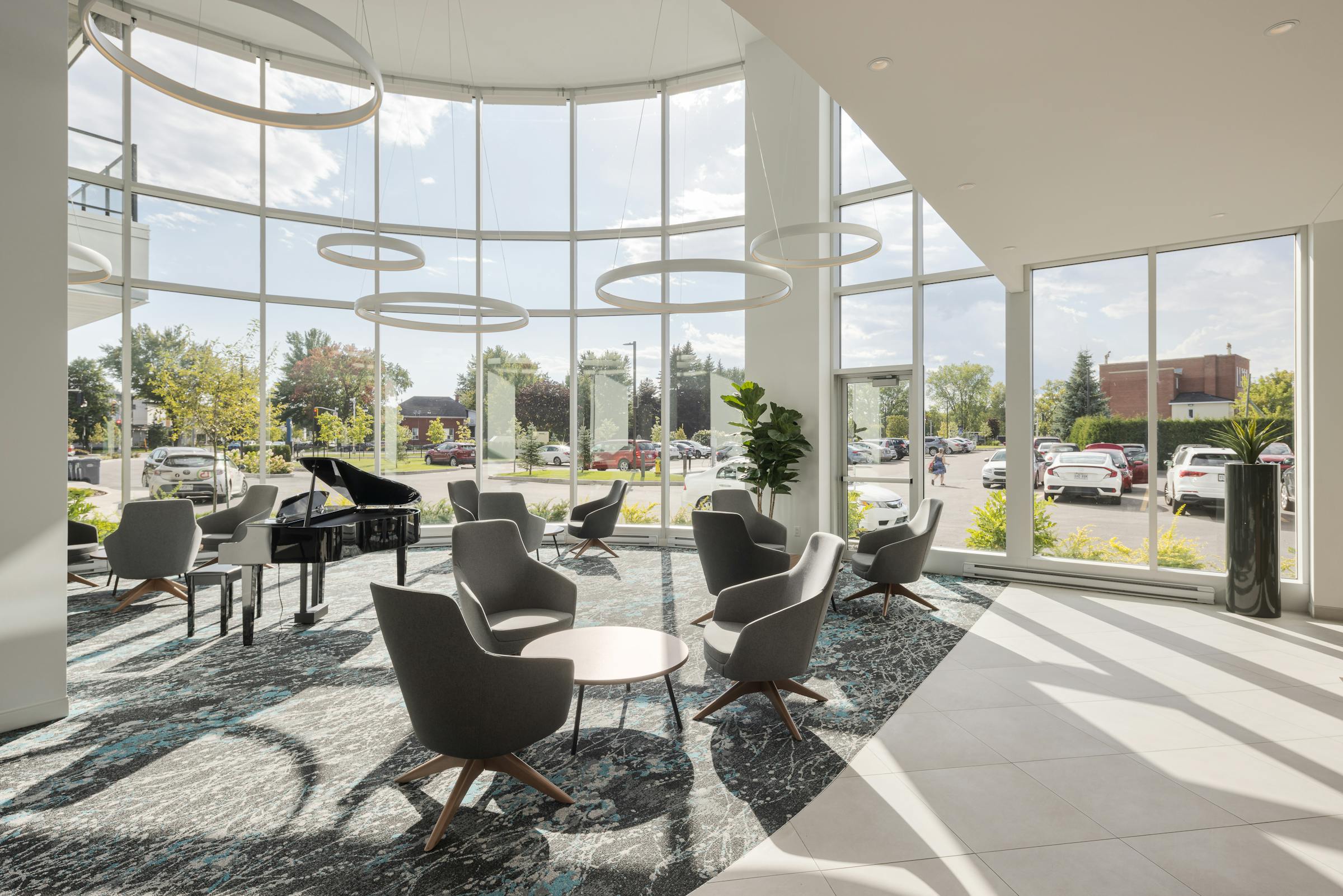 Bright interior design of the living room of a residence for the elderly (RPA) with large bay windows revealing the outside.