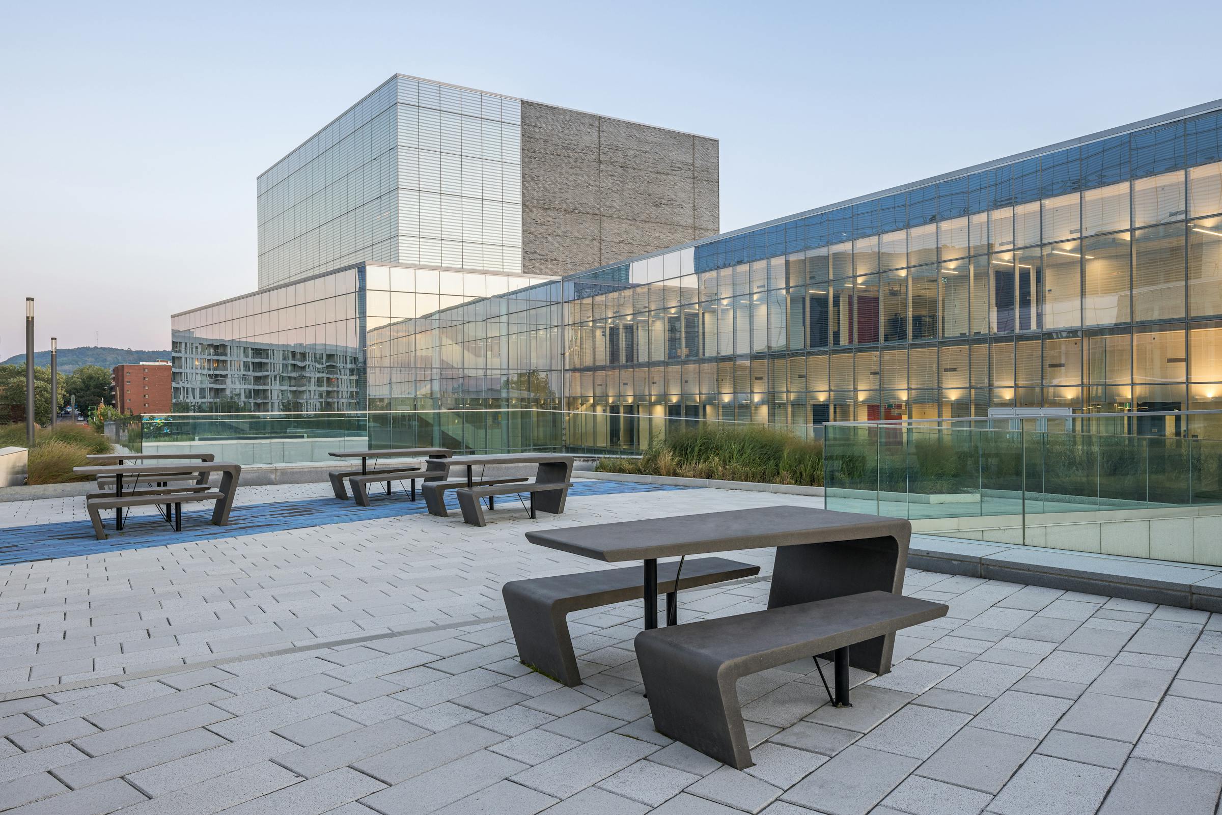 Pavilion A of the MIL Campus of the University of Montreal with concrete tables in the foreground.