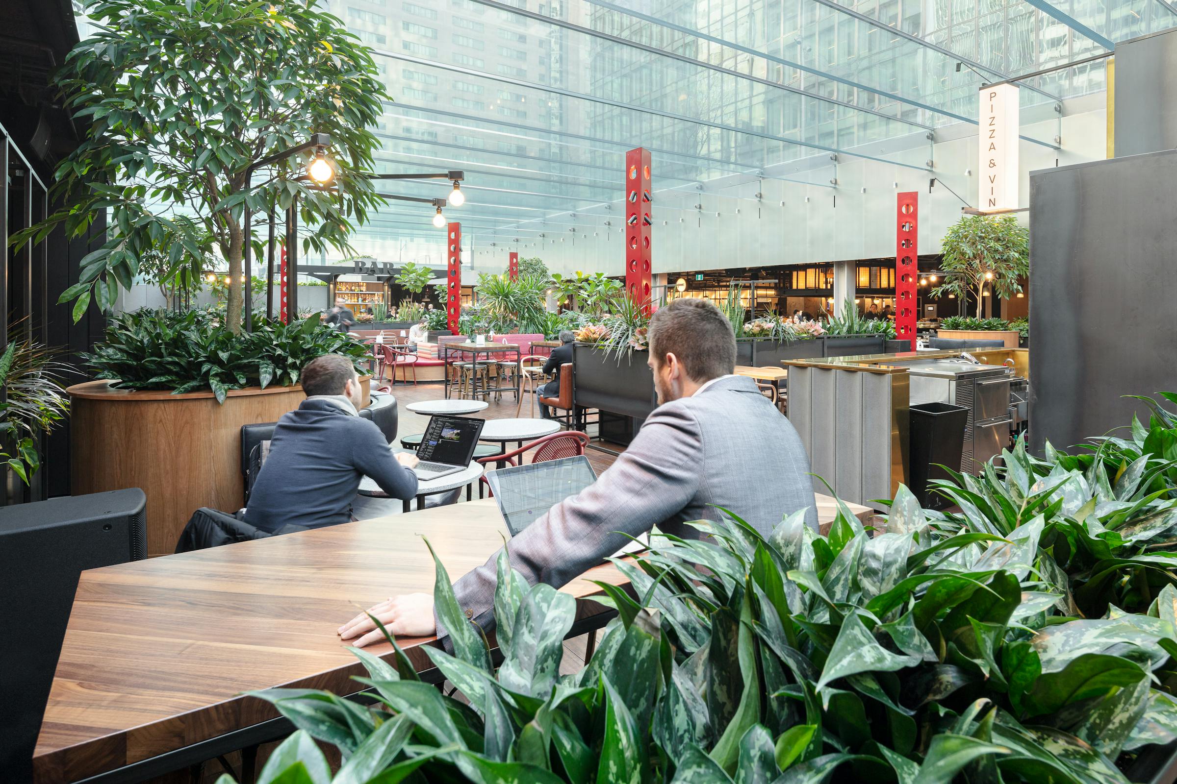 Photograph of a person working in a work and catering space with modern and surprising architecture.