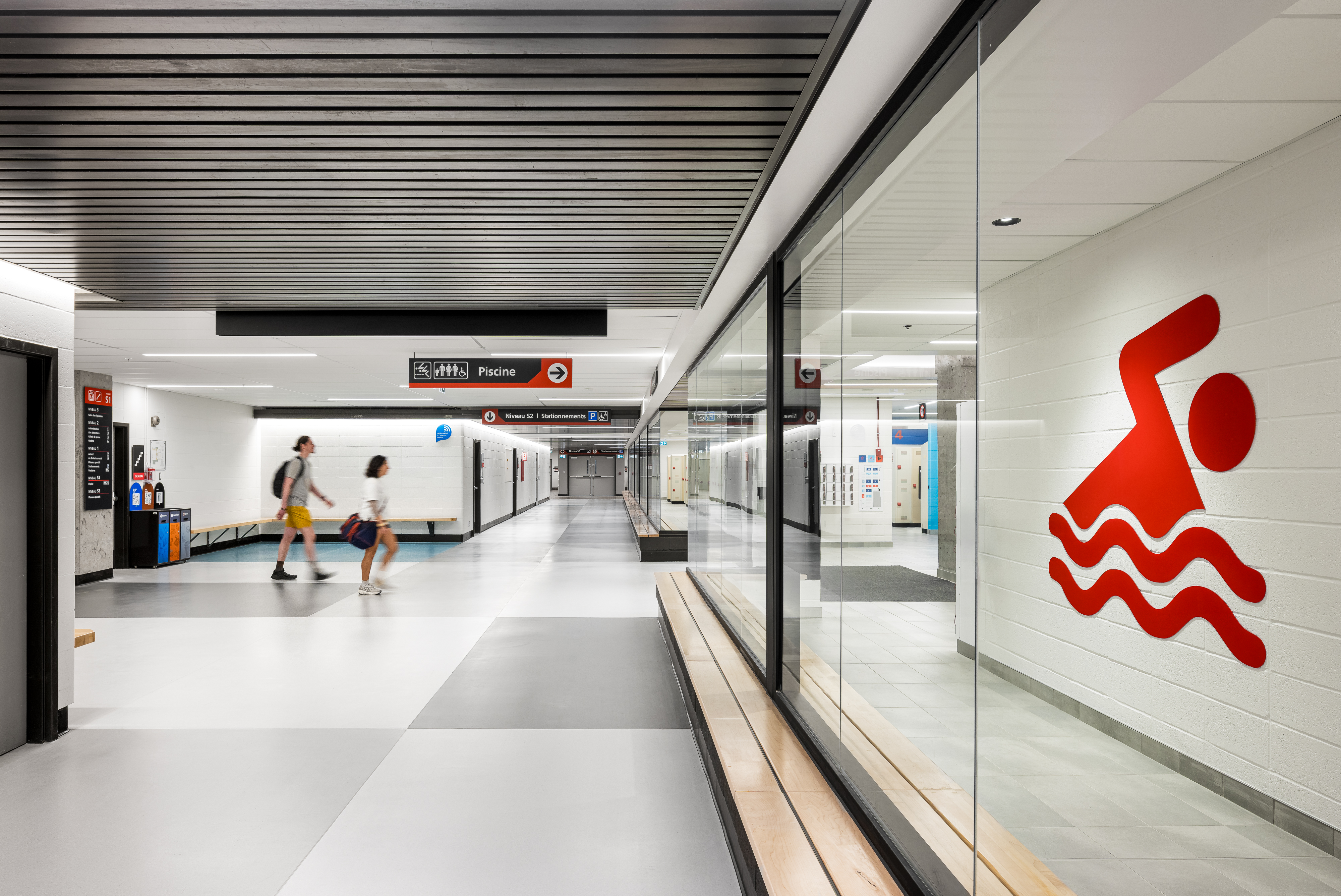 Interior architecture and signage photography, universal changing room corridor with swimming pictogram on glass wall.