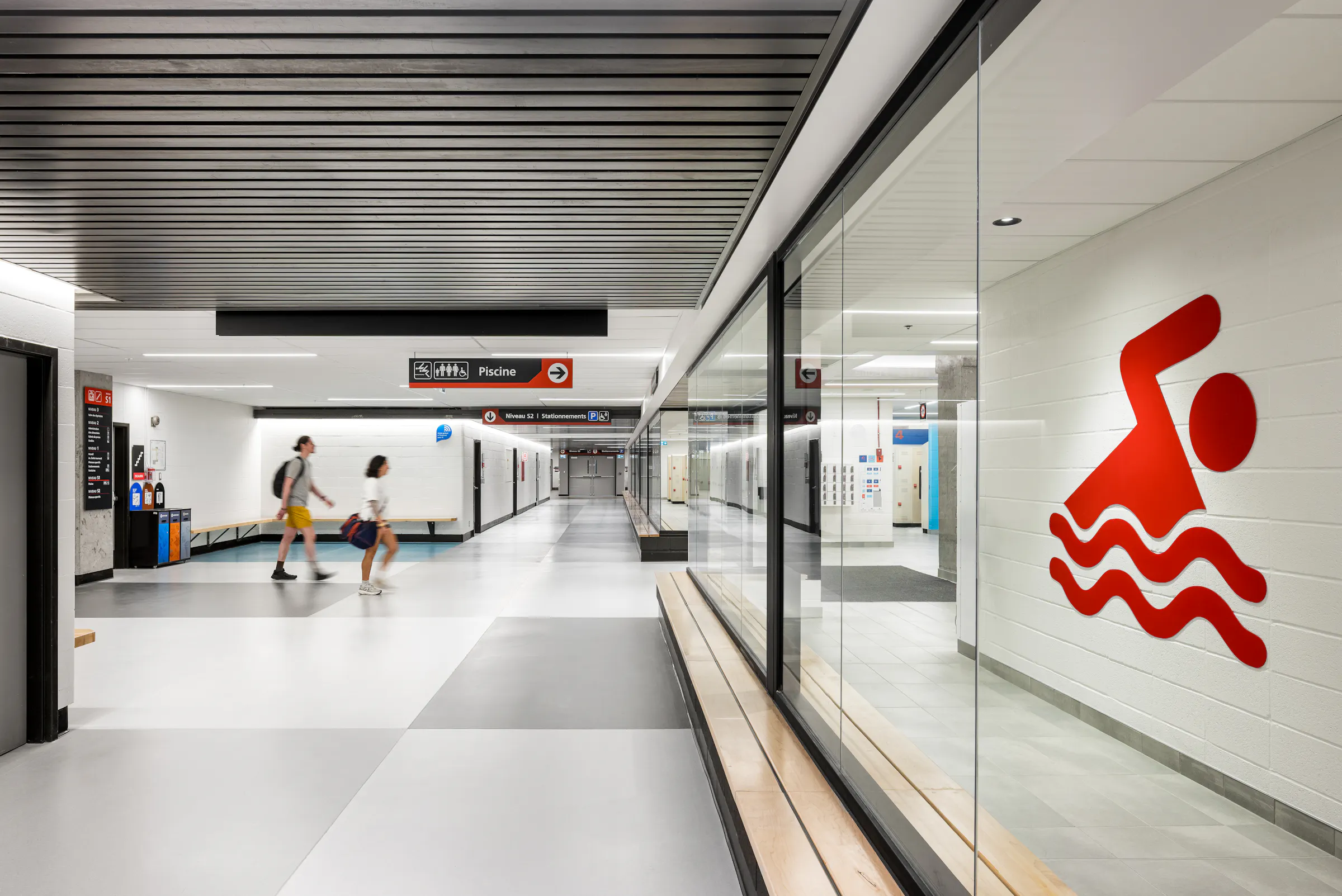 Interior architecture and signage photography, universal changing room corridor with swimming pictogram on glass wall.
