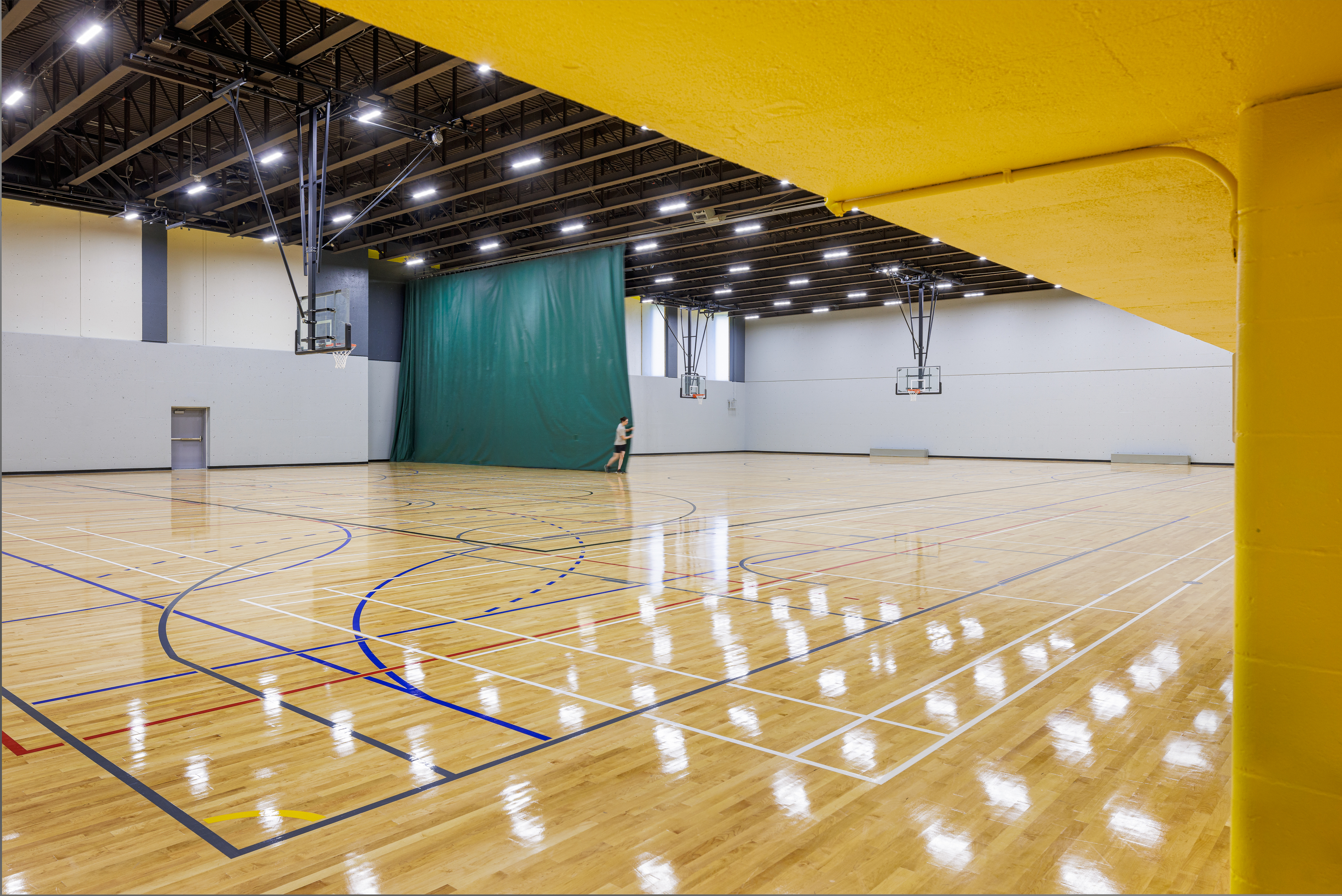 Interior design photograph, basketball court and yellow wall of the gymnasium at the Claude-Robillard Sports Complex.