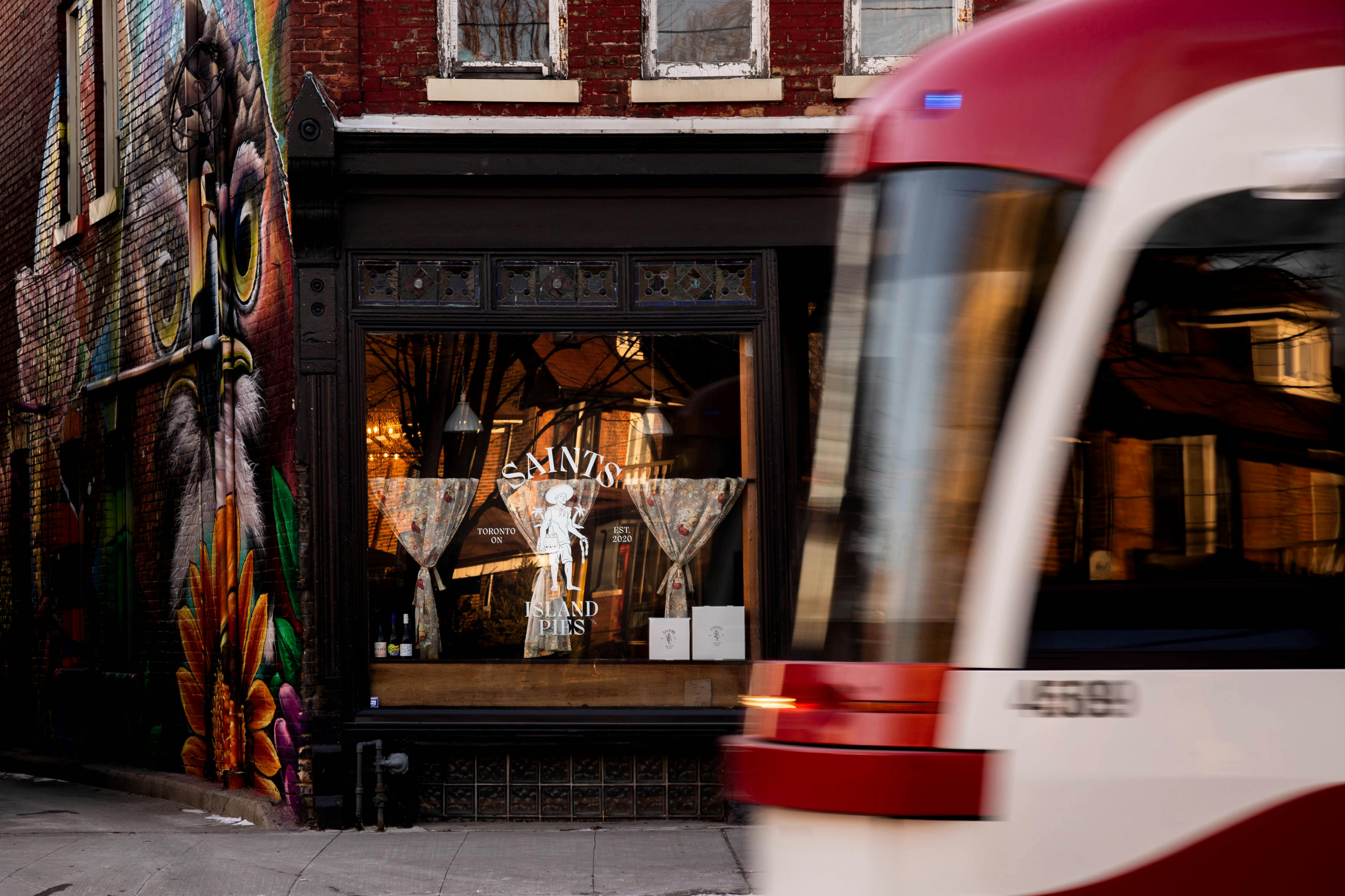 A TTC streetcar passes by Saints Island Pies restaurant on Dundas Street West in Toronto.