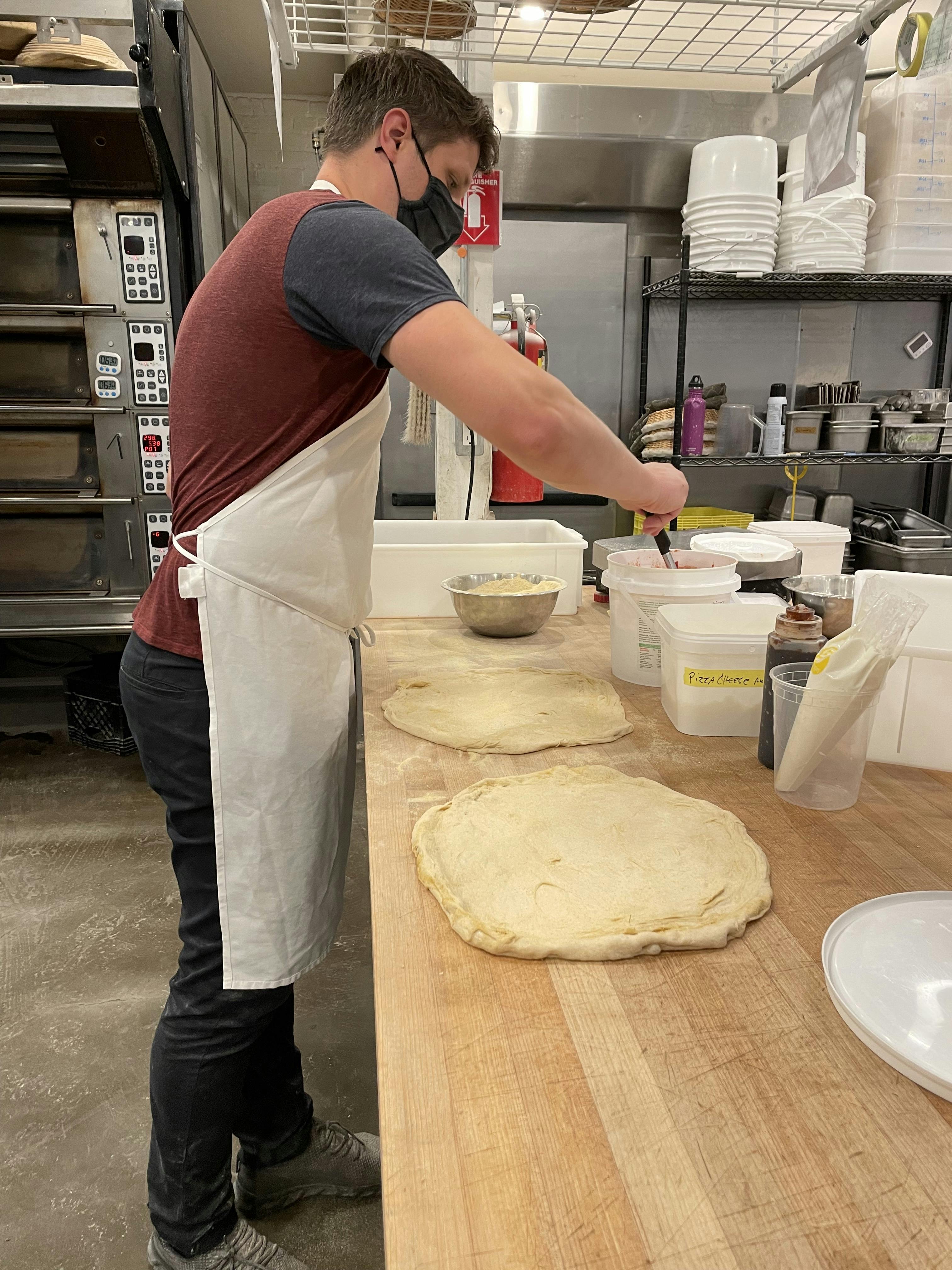 Kitchen and Mill manager Anthony Togeretz, preparing pizza using freshly milled dough