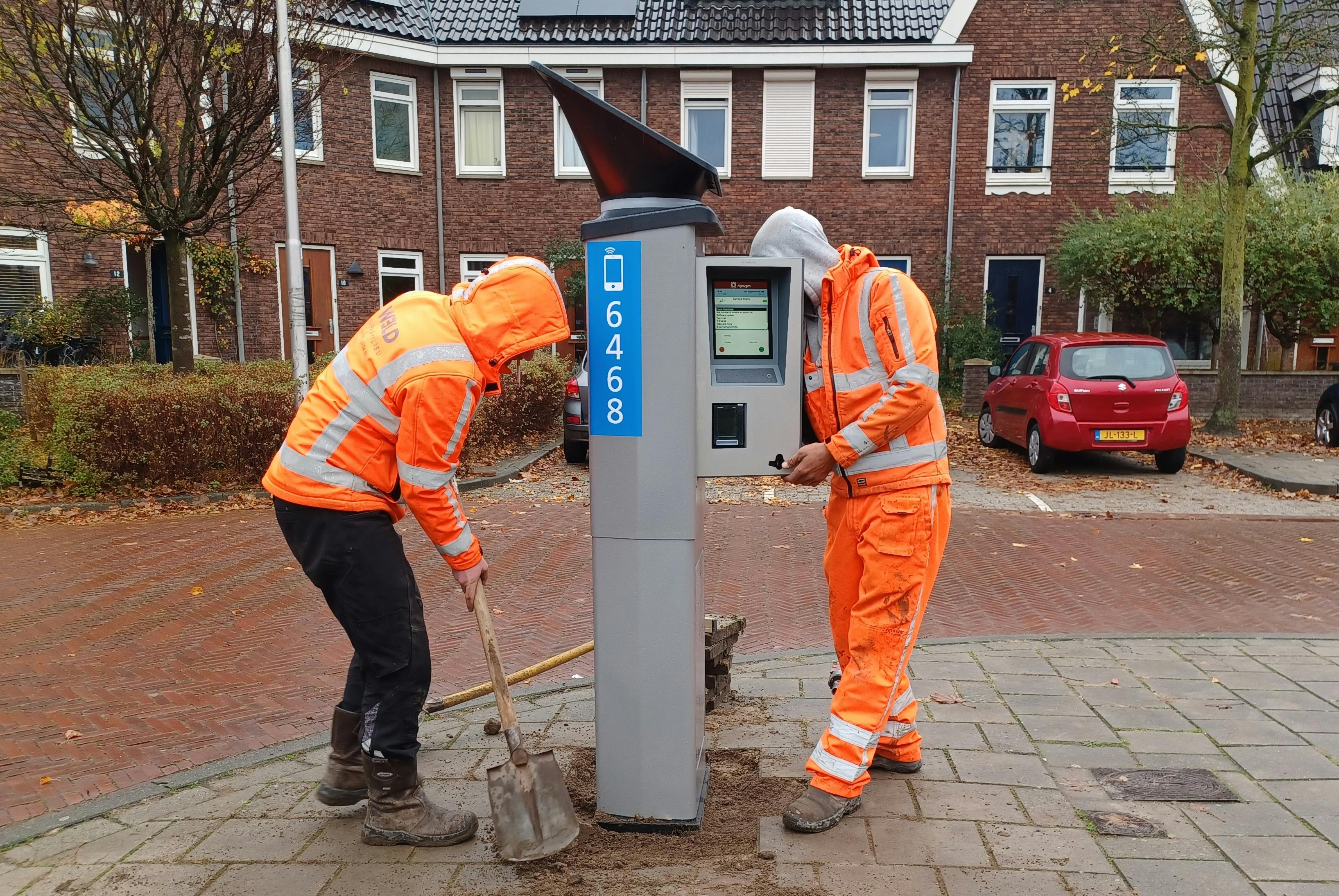 2 monteurs werken aan een parkeerautomaat