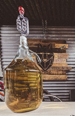 A picture of a demijohn with cyser in secondary ferment