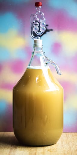 A photo of a demijohn filled with mead