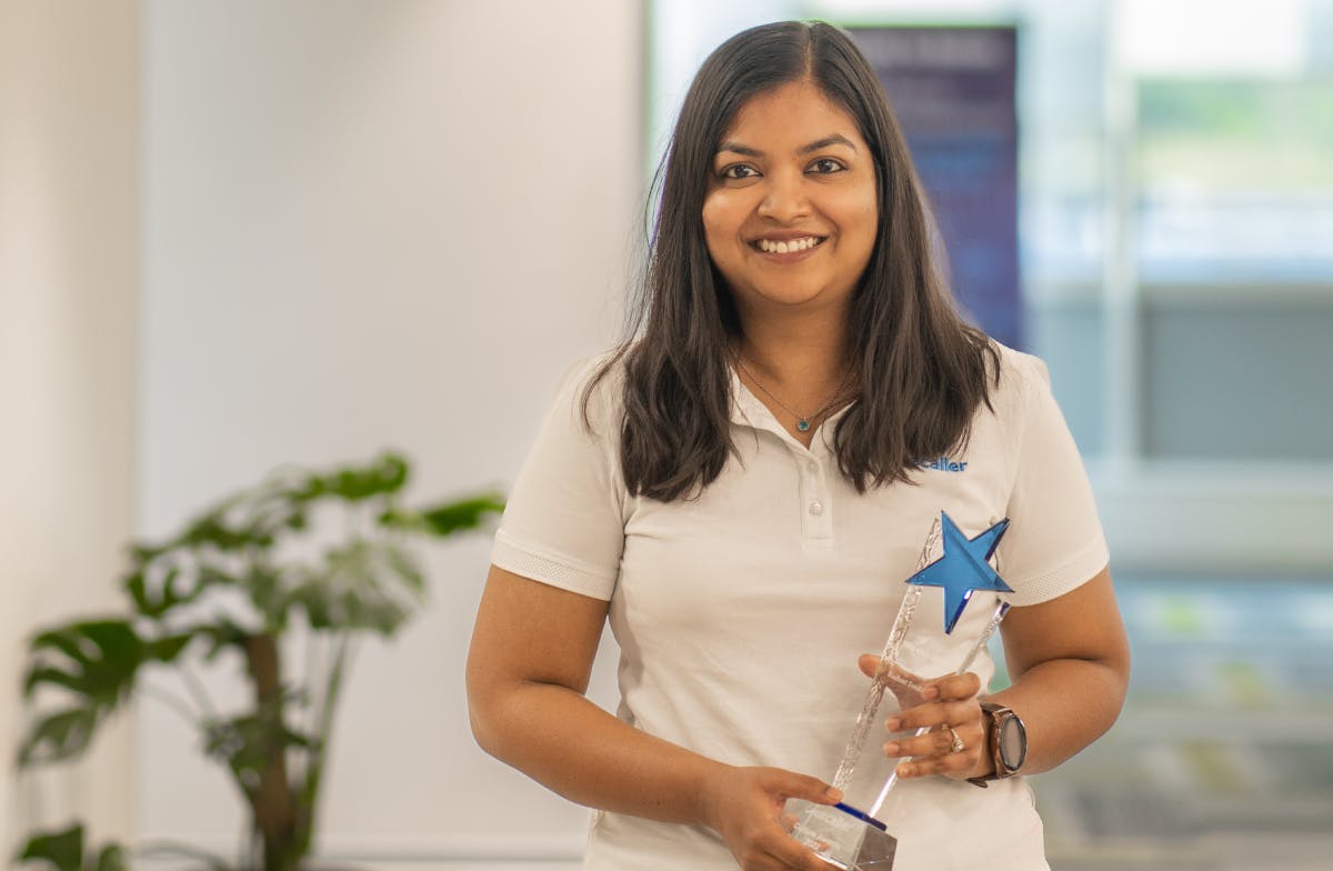 Rashmi holding the 'Help Each Other' Award.