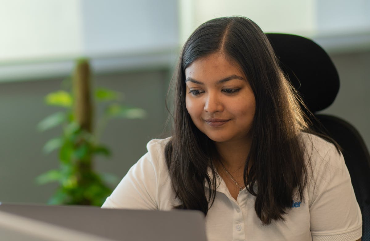 Rashmi working on her computer at her desk in the Bangalore office.