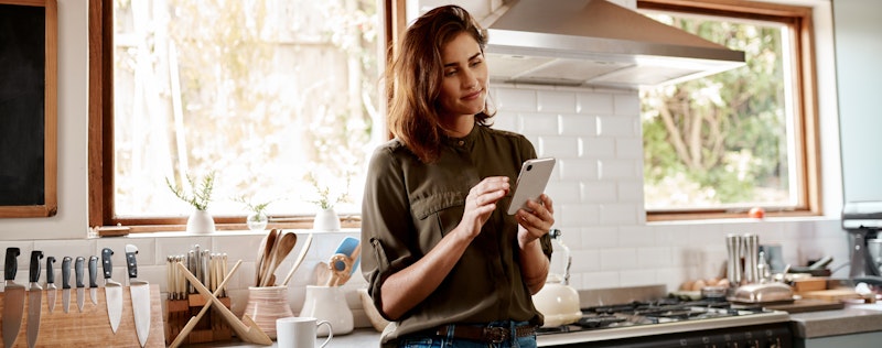 woman looking at phone in kitchen