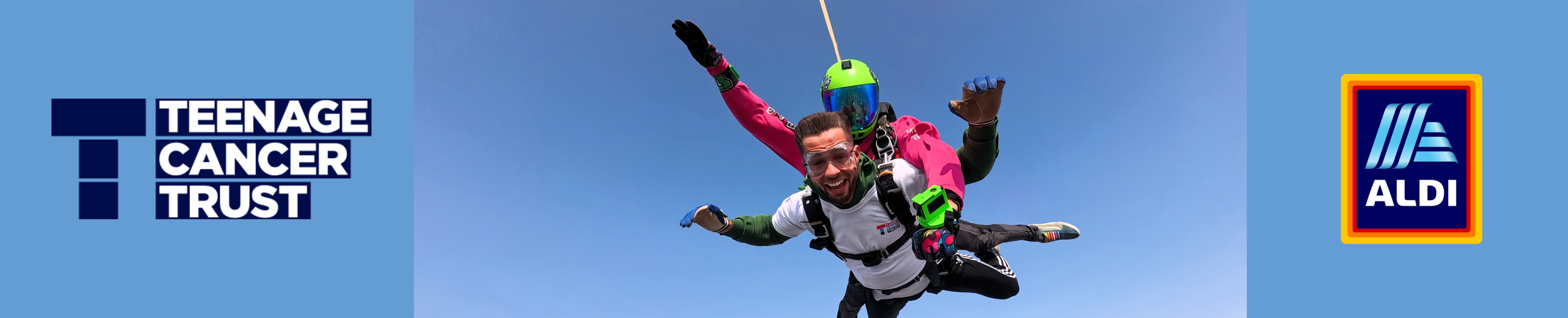 Skydiver in tandem freefall against a clear blue sky, promoting Teenage Cancer Trust with Aldi branding.