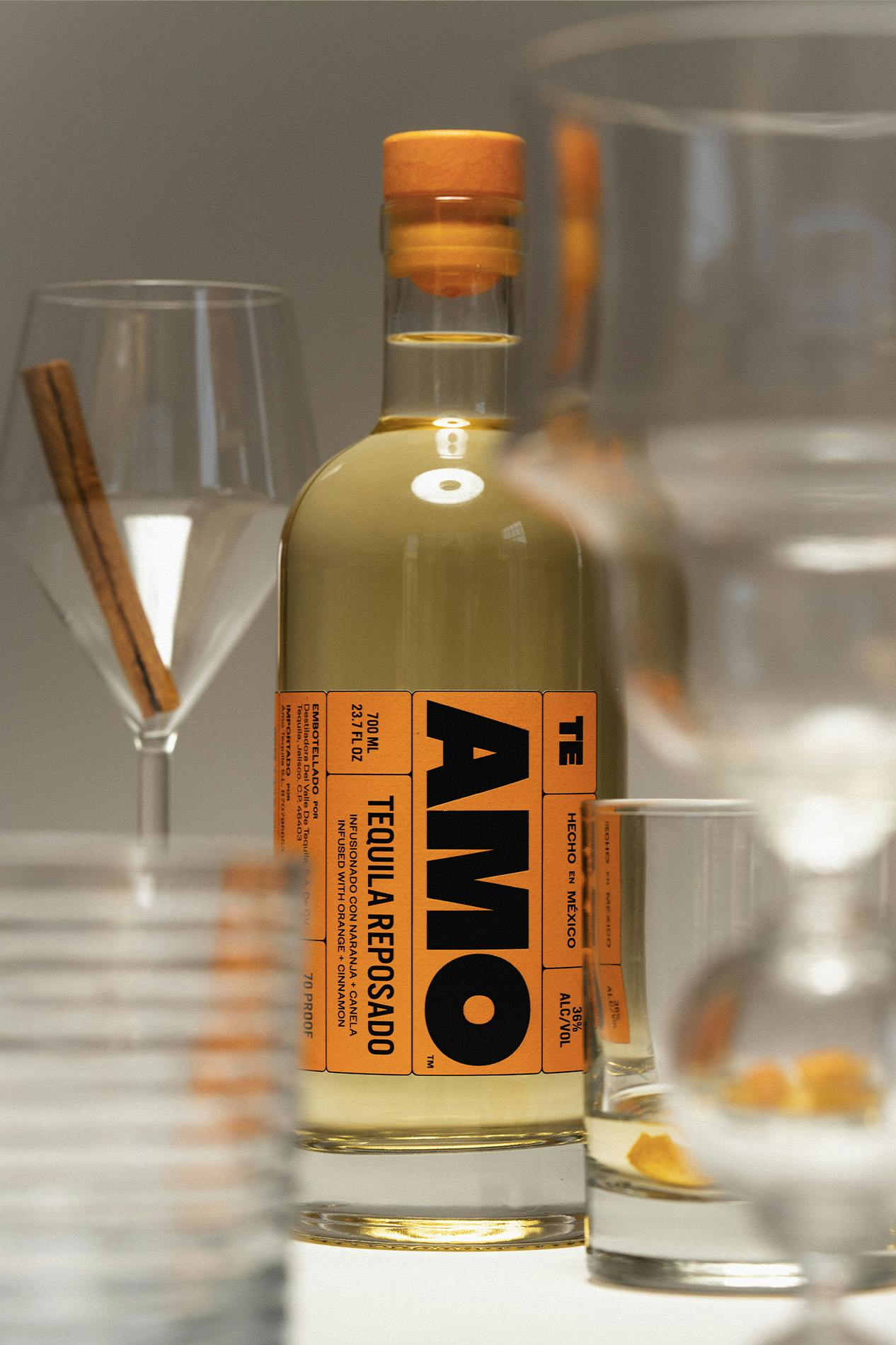 AMO Tequila bottle surrounded by cocktail and wine glasses