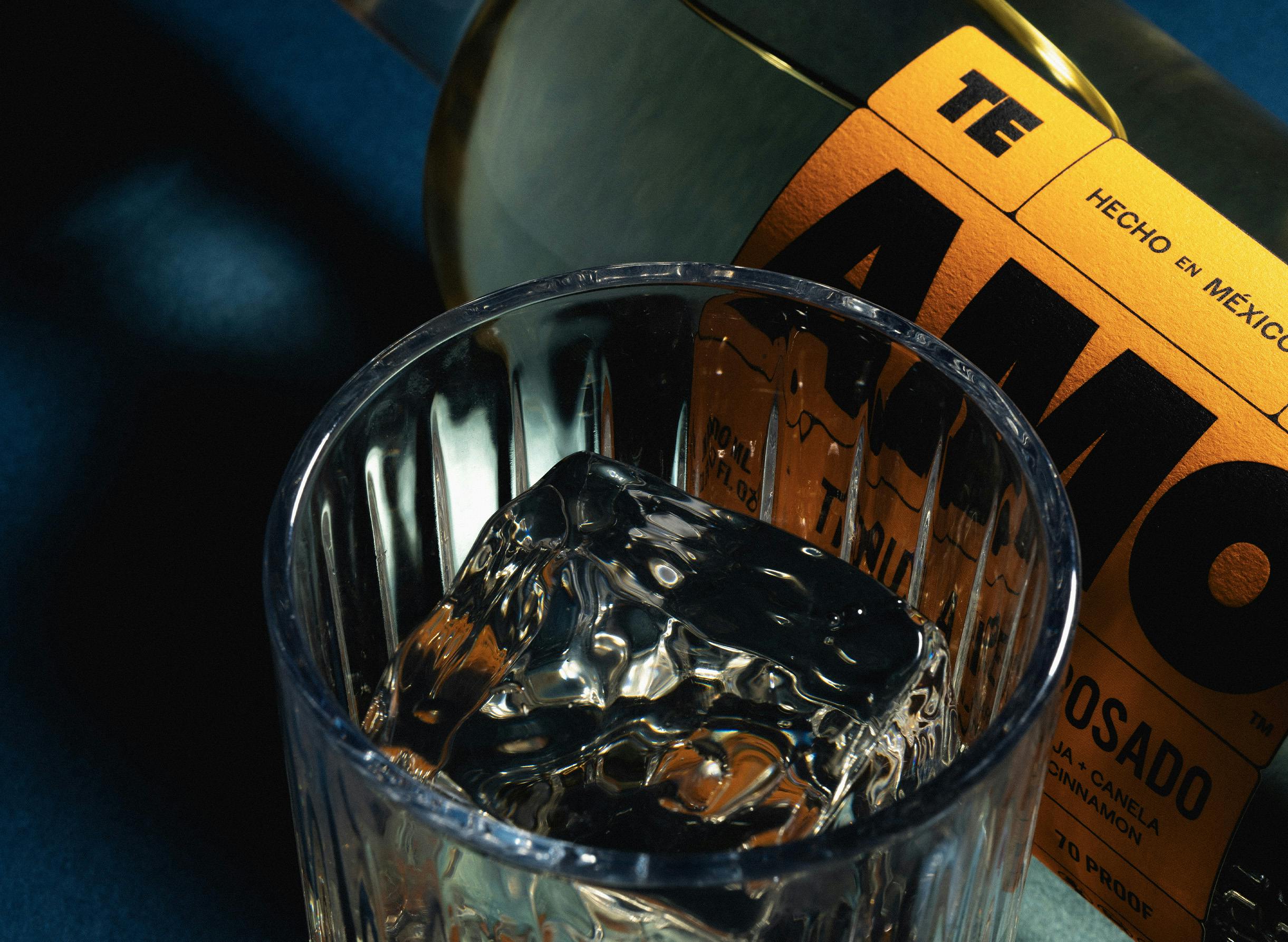 cocktail glass next to bottle of AMO Tequila