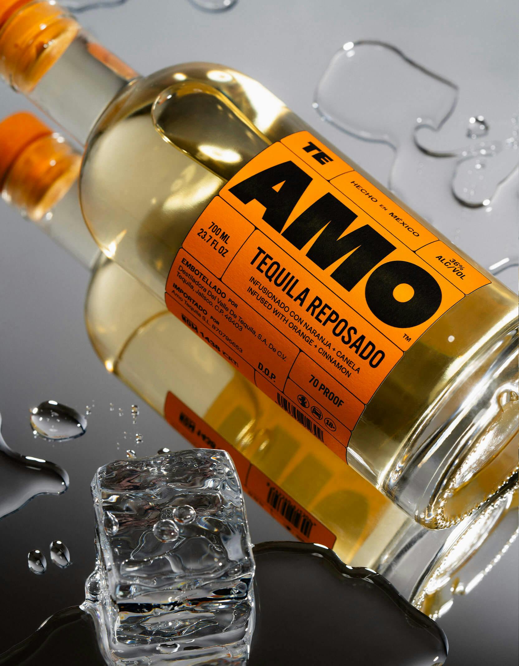 AMO Tequila bottle on mirror with water pools and ice cube