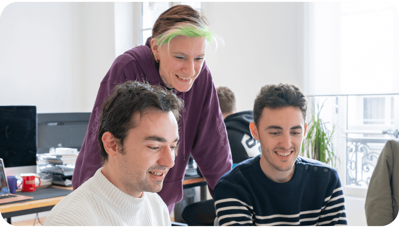 3 salariés Teach Up regardant l'écran d'un ordinateur
