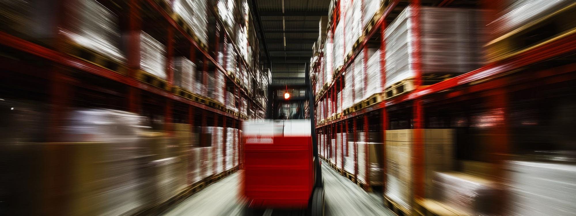 Moderne Intralogistik Anbieter im Einsatz – Gabelstapler bewegt Waren effizient durch ein Hochregallager mit Paletten und automatisierten Prozessen.