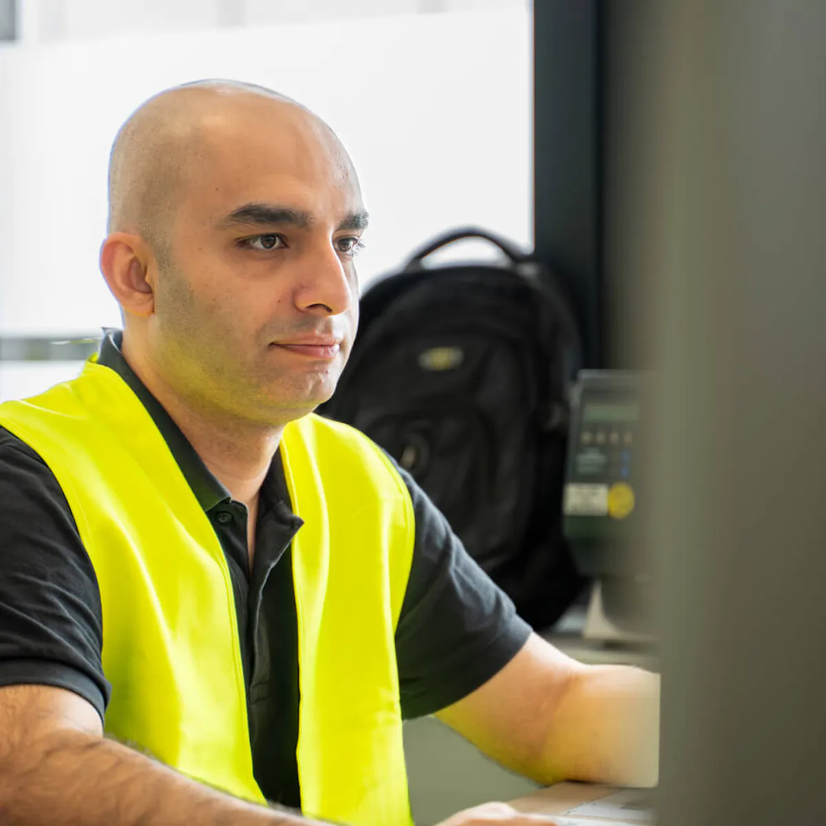 Qualifizierter Industriemitarbeiter mit gelber Warnweste bei der Arbeit – TEAMProjekt Outsourcing stellt geschulte Fachkräfte für Sicherungsposten-Einsätze in der Industrie.