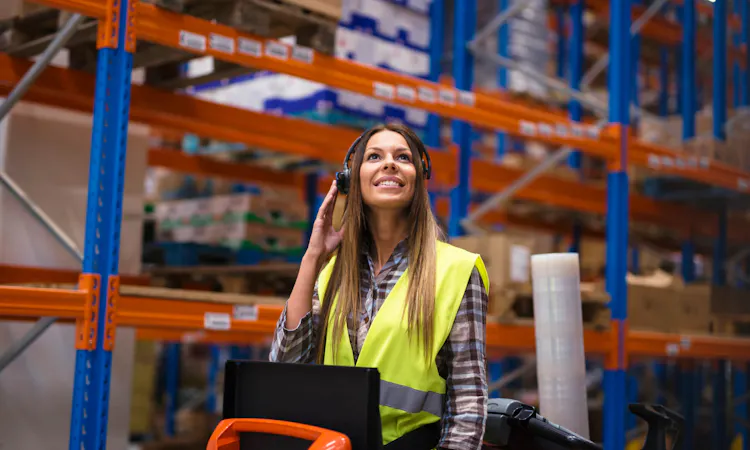 Mitarbeiterin im Lager kommuniziert über Pick-by-Voice
