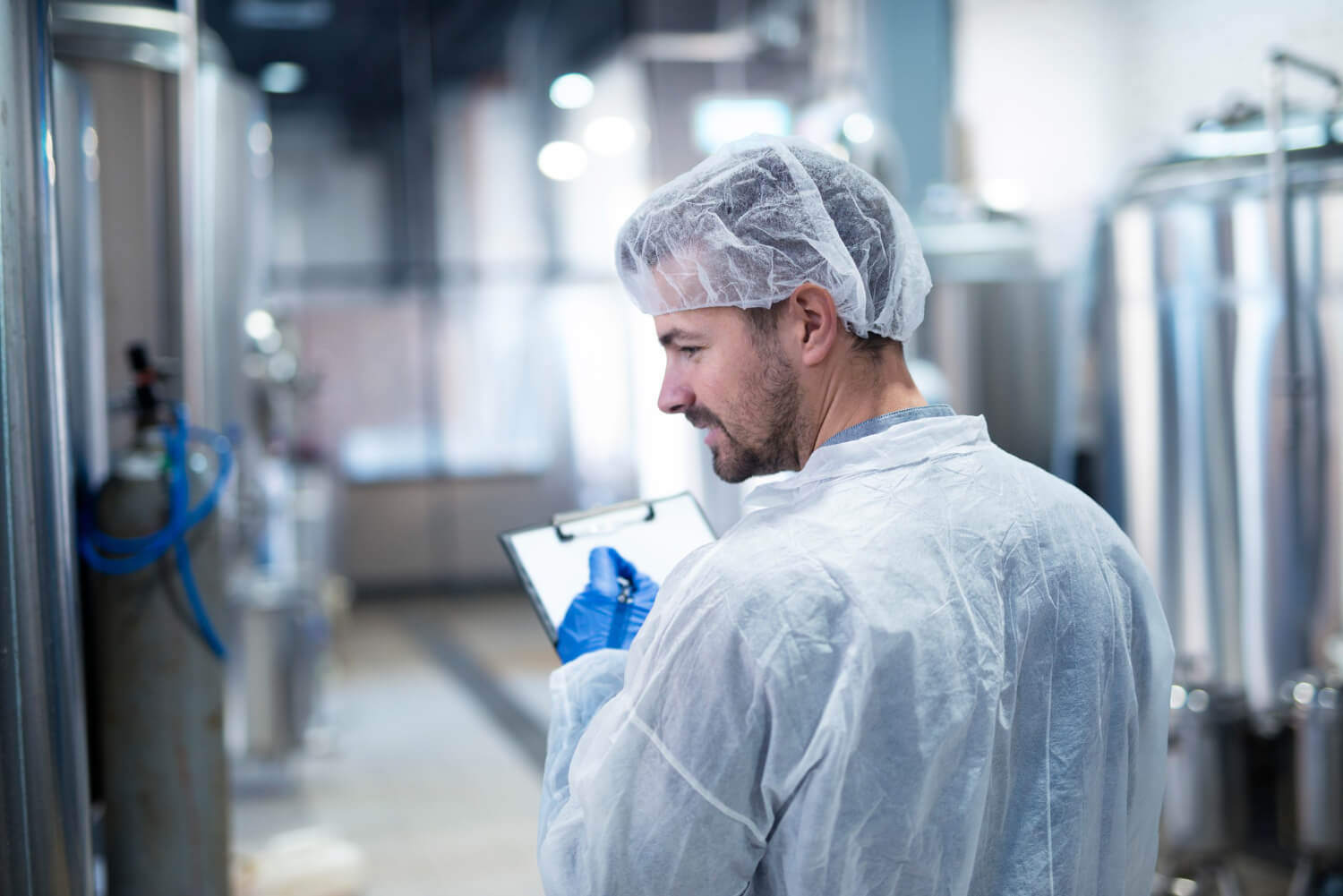 Qualitätskontrolle in der Reinraumproduktion – Mitarbeiter dokumentiert Prozesse nach GMP und Hygienevorgaben
