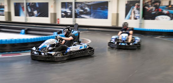 Zwei Karts auf der Rennstrecke fahren um die Kurve und liefern sich ein spannendes Rennen.