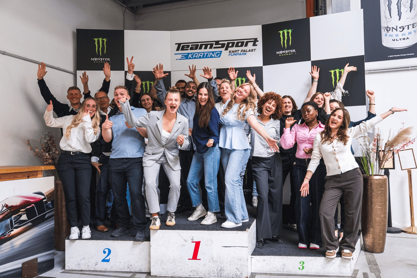 Eine Gruppe an Menschen auf dem Podium jubelt und feiert 