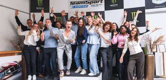 Eine Gruppe an Menschen auf dem Podium jubelt und feiert