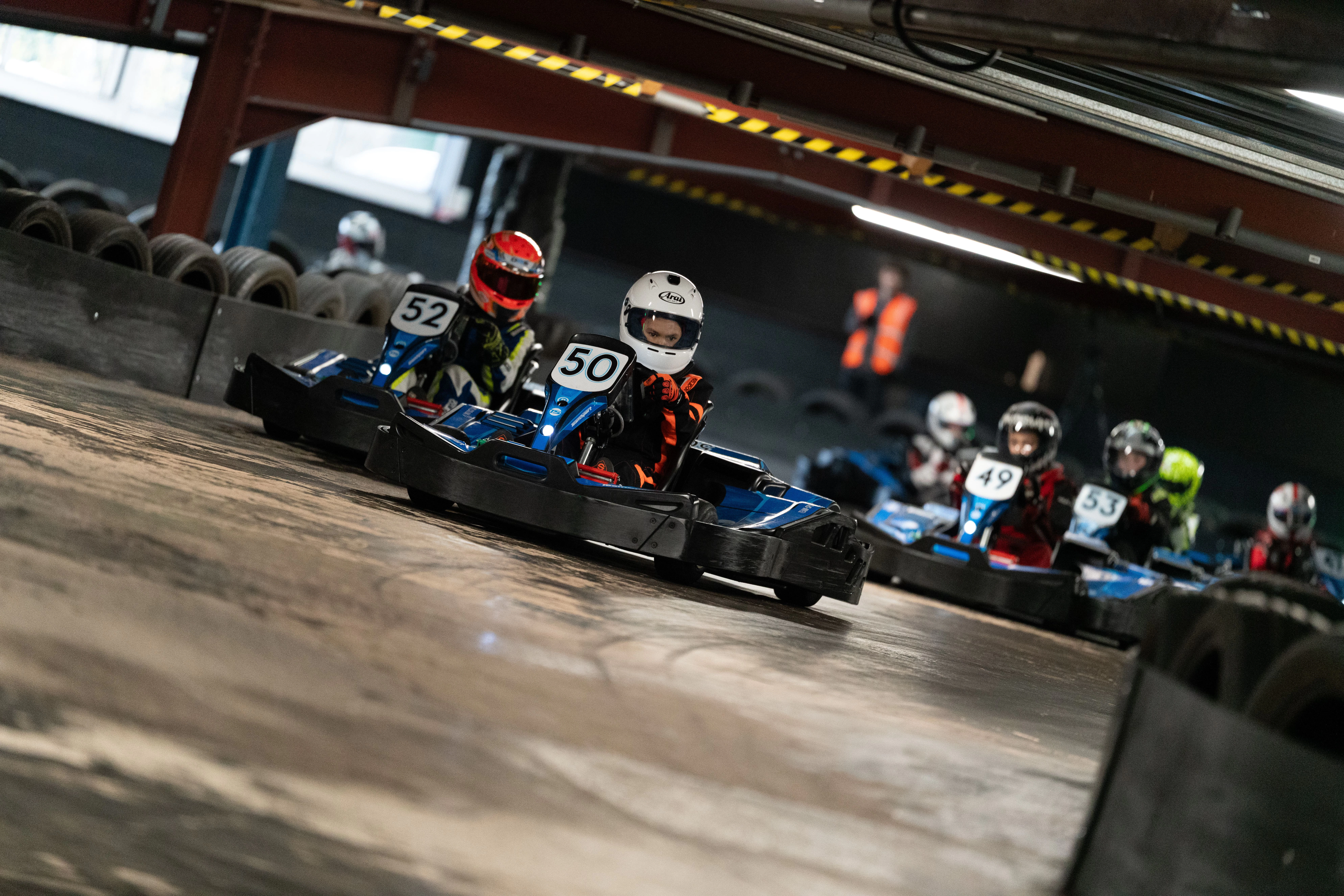 Go-kart driver overtaking another racer on an indoor karting track