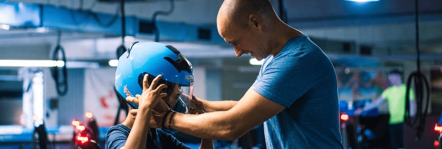 Ein Vater setzt seinem Kind den Helm vor dem Rennen auf