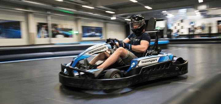 Een man zit in een kart en neemt deel aan een race