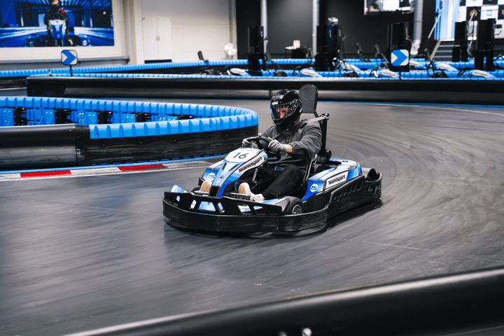 Mann in einem Go Kart, der an einem Rennen teilnimmt. 