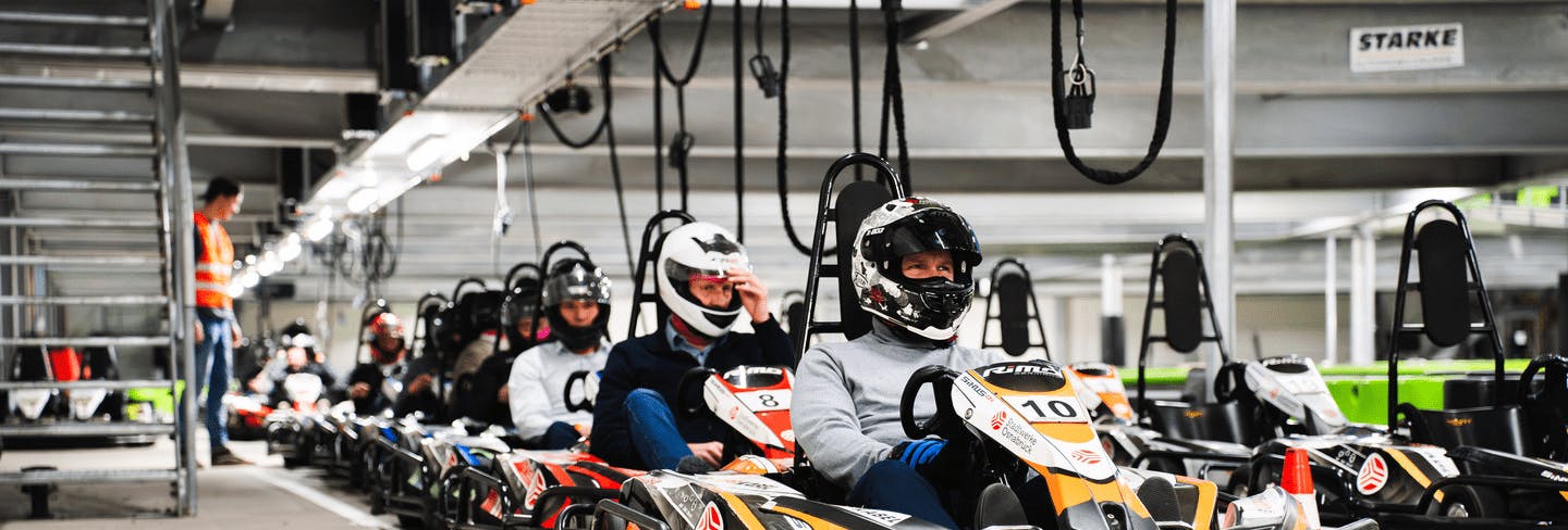  Gruppe von E-Kart-Fahrern wartet darauf, auf unserer Indoor-Kartbahn Rennen zu fahren