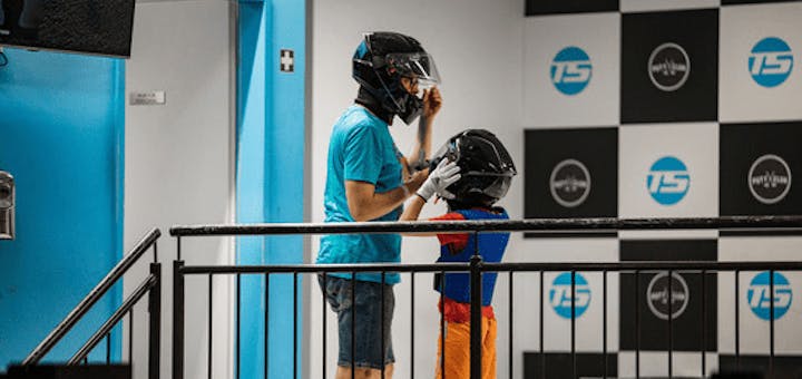 Ein Vater hilft seinem Kind den Helm anzuziehen