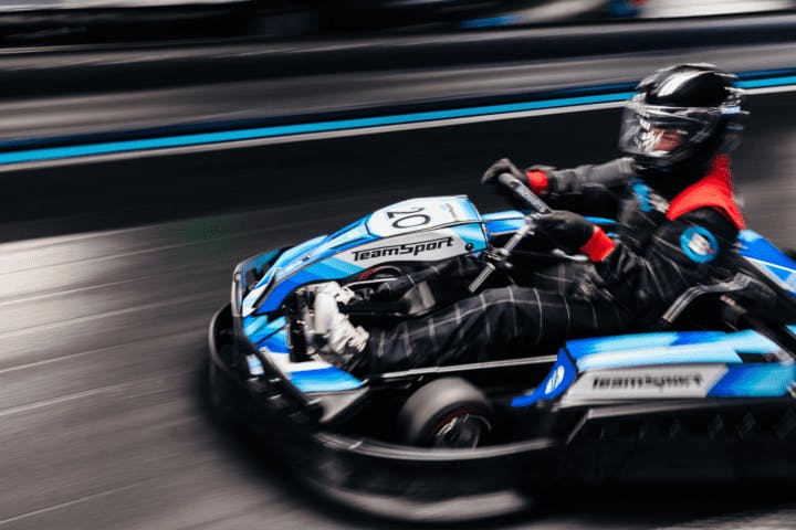 Adult going fast in an electric blue go kart