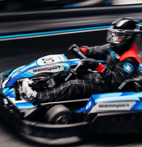 Adult going fast in an electric blue go kart