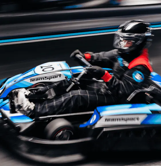 Adult going fast in an electric blue go kart