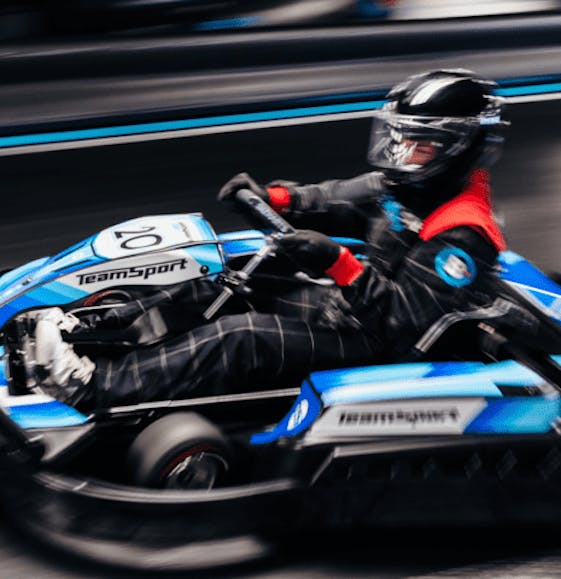 Adult going fast in an electric blue go kart