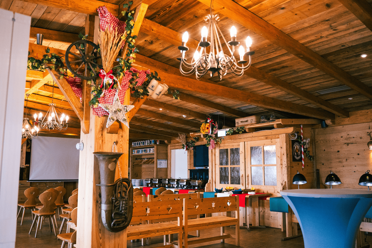 Überblick über das Eventstadl. Aufgebaute Sitzreihen vor einer Leinwand. 