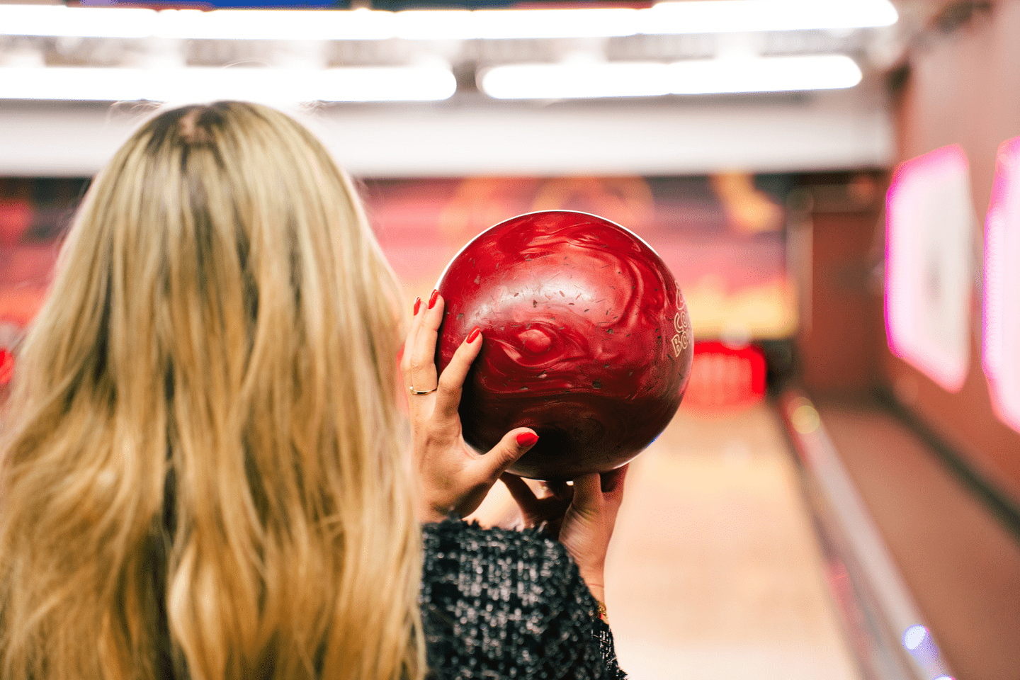 Eine Frau hält eine Bowlingkugel in der Hand