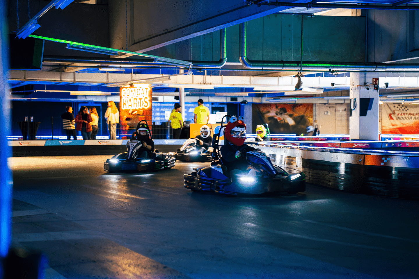 Mehrere Kartfahrer auf der Combat Kart Rennstrecke mit Plüsch-Helm Covern
