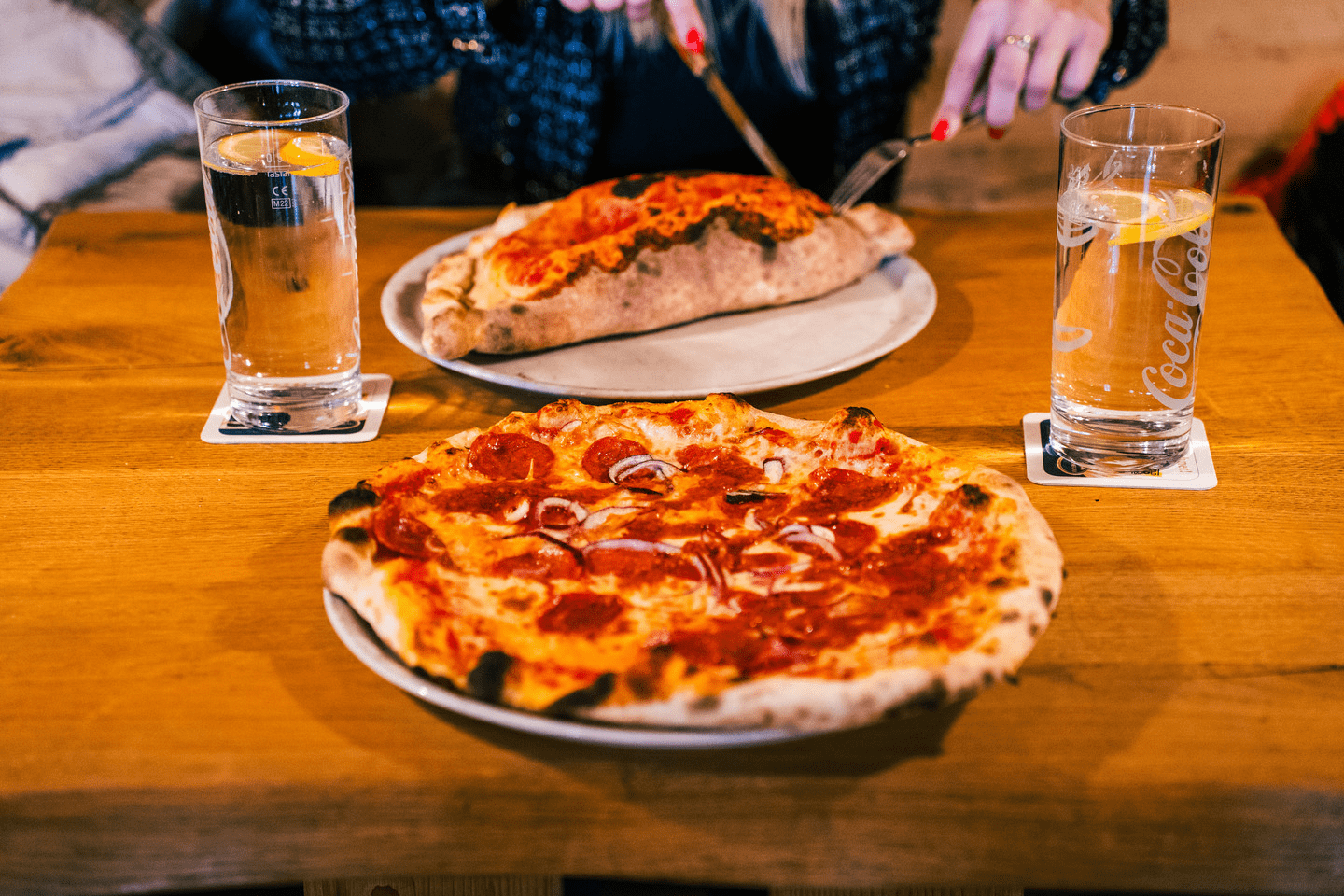 Eine Salami Pizza und eine Pizza Calzone aus unserem Holzofen mit zwei Getränken 