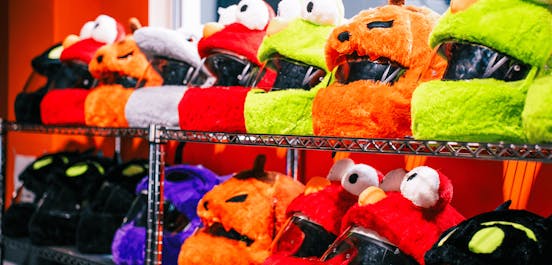 Ein Regal mit Helmen, welche unsere Plüsch-Helm-Cover tragen