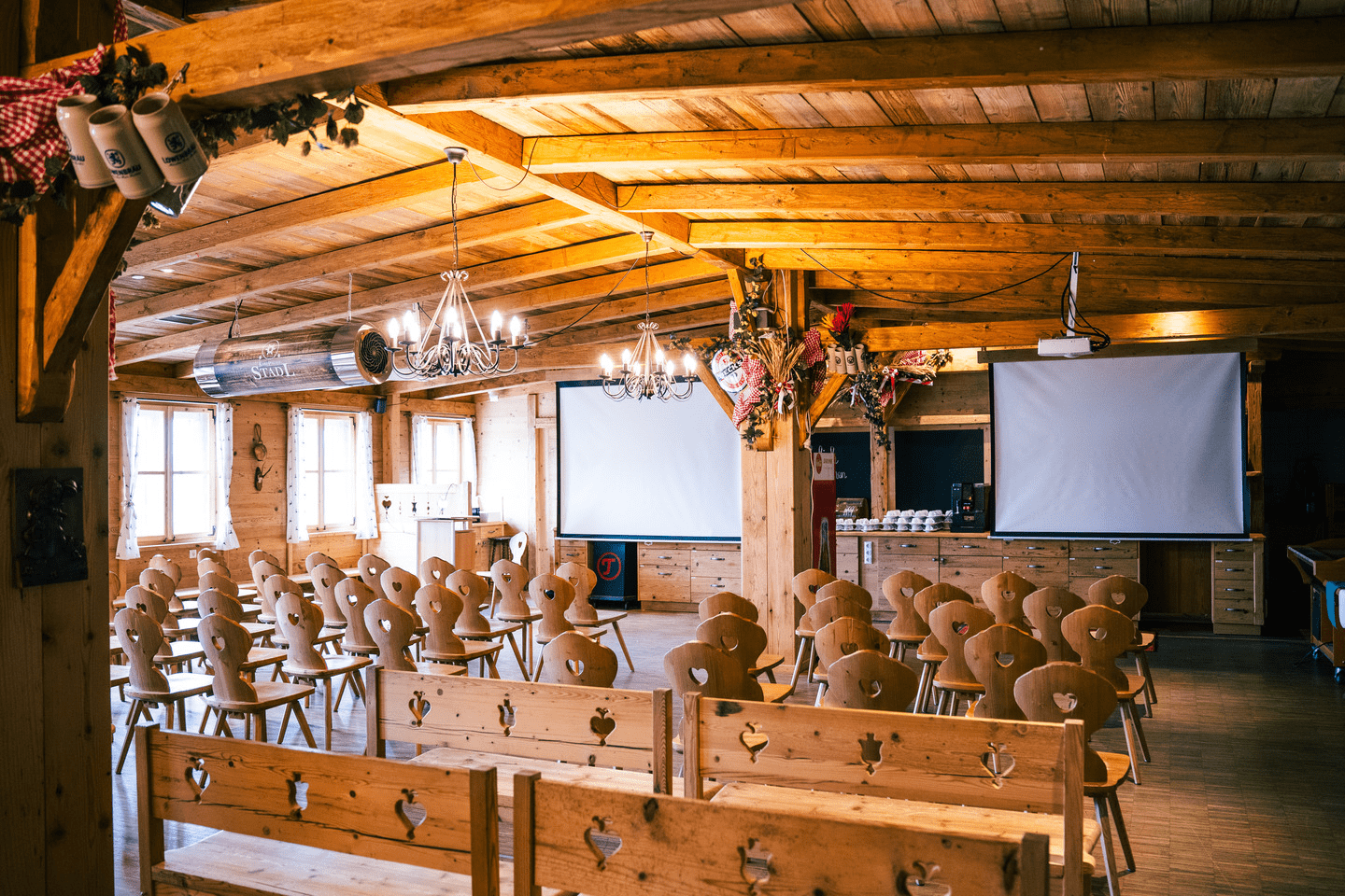 Das Eventstadl mit aufgebauten Sitzreihen und 2 Bildschirmen bereit für die nächste Veranstaltung