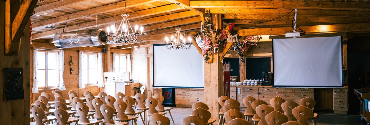 Aufgebaute Sitzreihen im Eventstadl mit 2 Leinwänden